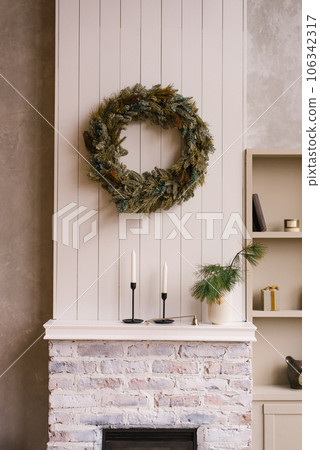 Christmas wreath hangs on a wooden wall in a Scandinavian-style house Christmas wreath hangs on a wooden wall in a Scandinavian-style house 106342317