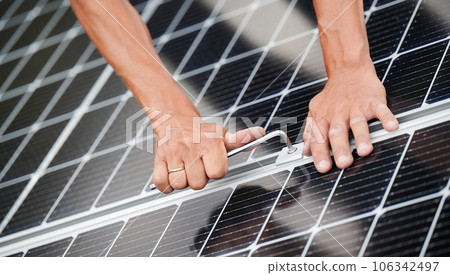 Man technician mounting photovoltaic solar moduls on roof of house. Close up of engineer installing solar panel system outdoors, tightening with hex key. Concept of alternative and renewable energy. 106342497