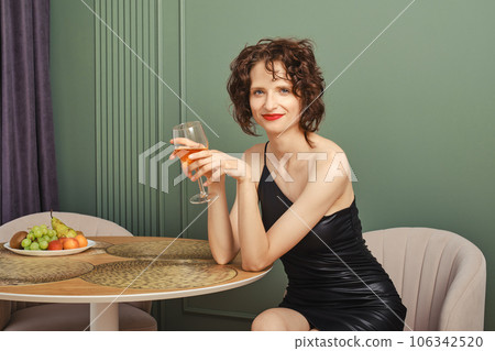 Portrait of happy woman with a glass of wine 106342520