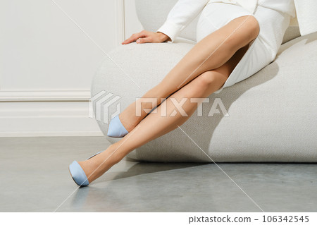 Female legs in beige tights on sofa 106342545