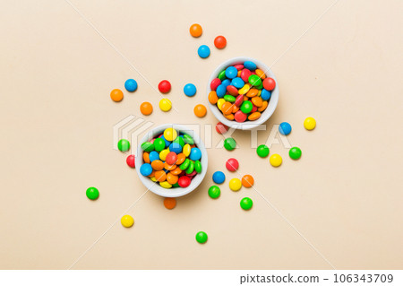 different colored round candy in bowl and jars. Top view of large variety sweets and candies with copy space 106343709