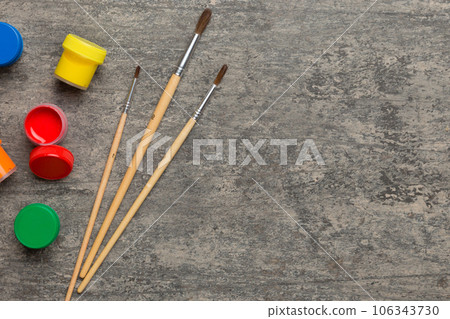 art palette with paint and brushes, close up. Top view with empty space. workplace for creativity. home teaching concept drawing art palette with paint and brushes, close up. Top view with empty space. workplace for creativity. home teaching concept drawing 106343730