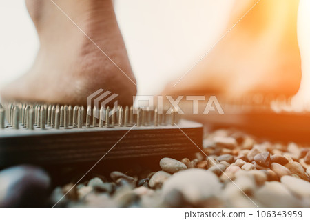 Sea Woman feet stepping on sadhu board during indian practice on the seashore. . Healthy lifestyle concept. tool for working out your inner state 106343959