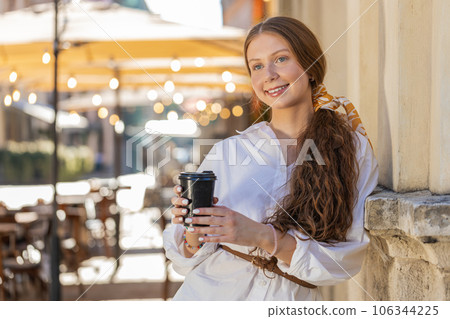 Teen child girl enjoying drinking morning coffee hot drink, relaxing, taking a break in city street Teen child girl enjoying drinking morning coffee hot drink, relaxing, taking a break in city street 106344225