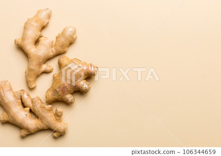 Finely dry Ginger powder in bowl with green leaves isolated on colored background. top view flat lay Finely dry Ginger powder in bowl with green leaves isolated on colored background. top view flat lay 106344659