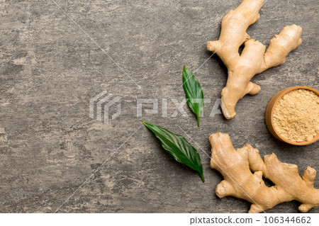 Finely dry Ginger powder in bowl with green leaves isolated on colored background. top view flat lay Finely dry Ginger powder in bowl with green leaves isolated on colored background. top view flat lay 106344662