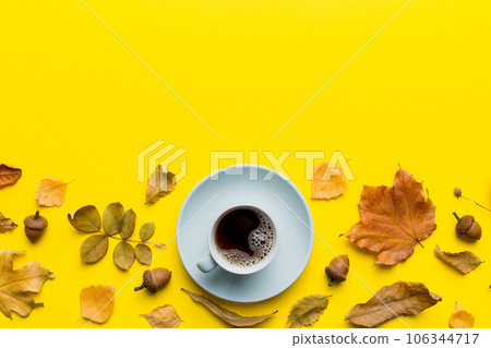 Flat lay composition with colorful Autumn cup of coffee and leaves on a color background. top view Flat lay composition with colorful Autumn cup of coffee and leaves on a color background. top view 106344717