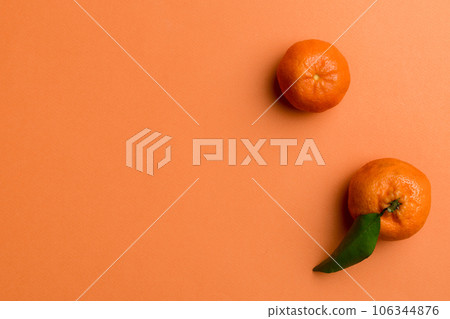 Many fresh ripe mandarin with green leaves on colored background, top view, space for text 106344876