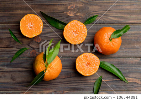 Many fresh ripe mandarin with green leaves on colored background, top view, space for text Many fresh ripe mandarin with green leaves on colored background, top view, space for text 106344881
