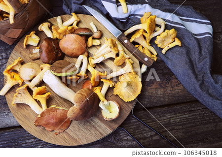 Mix of forest mushrooms on cutting board over old wooden table 106345018