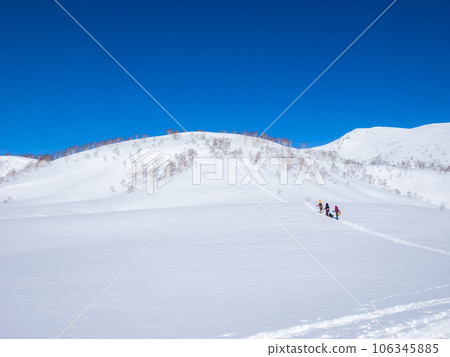 People carrying snowboards walking on a snowy field toward a hill (Hokkaido, Kutchan town, around the Iwaonupuri trailhead) People carrying snowboards walking on a snowy field toward a hill (Hokkaido, Kutchan town, around the Iwaonupuri trailhead) 106345885