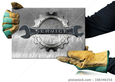 Gloved Hands Holding a Metal Sign with Steel Wrench and Gear 106346358