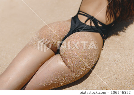 Sunbathing of Bikini Beach Woman Buttocks in Black Swimsuit on Sandy Beach Sunbathing of Bikini Beach Woman Buttocks in Black Swimsuit on Sandy Beach 106346532