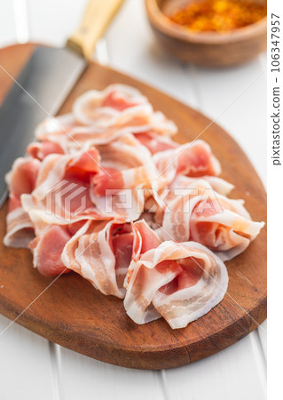 Italian panchetta. Sliced smoked bacon on cutting board. Italian panchetta. Sliced smoked bacon on cutting board. 106347957