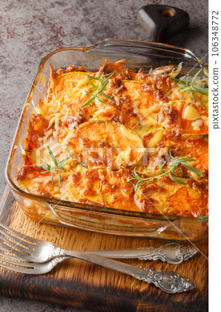 Sweet potato casserole with cheddar cheese and rosemary close-up in a glass form. Vertical 106348772