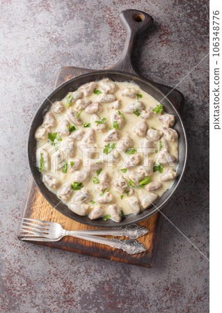 Home cooked chicken hearts in garlic creamy sauce close-up in a plate. Vertical top view Home cooked chicken hearts in garlic creamy sauce close-up in a plate. Vertical top view 106348776