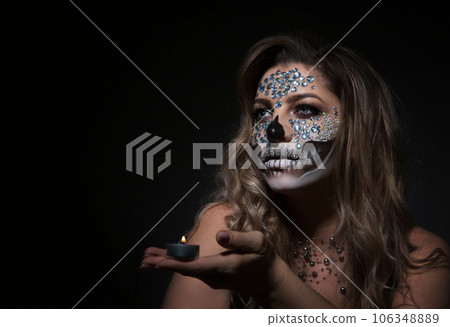 young woman with rhinestone makeup for Dia de los Muertos young woman with rhinestone makeup for Dia de los Muertos 106348889