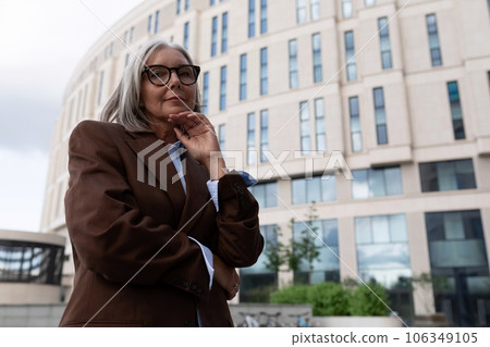 portrait of a confident well-groomed gray-haired middle-aged woman dressed in a stylish suit in an portrait of a confident well-groomed gray-haired middle-aged woman dressed in a stylish suit in an 106349105