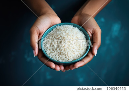 Female hands holding a bowl of rice 106349633