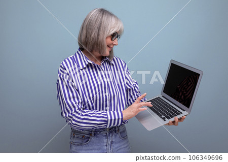 60s middle aged woman master remote professions online using laptop on bright studio background 60s middle aged woman master remote professions online using laptop on bright studio background 106349696