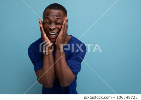 handsome friendly young african man in blue t-shirt smiling 106349725