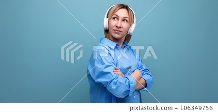 widescreen photo of a charming european girl in a casual shirt listening to music in big white widescreen photo of a charming european girl in a casual shirt listening to music in big white 106349756
