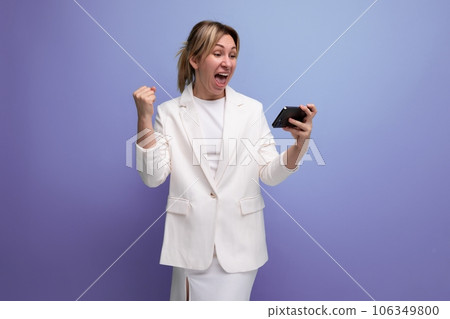 joyful young caucasian blondie lady in elegant jacket holding smartphone with mockup joyful young caucasian blondie lady in elegant jacket holding smartphone with mockup 106349800