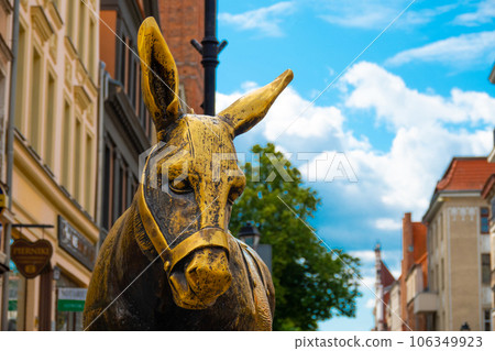 2022-07-06. Old bronze sculpture of a donkey on the street in the historical district of Torun. 106349923