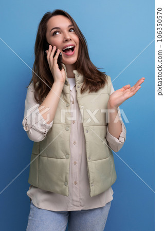 brunette young woman chatting on the phone on studio background 106350570