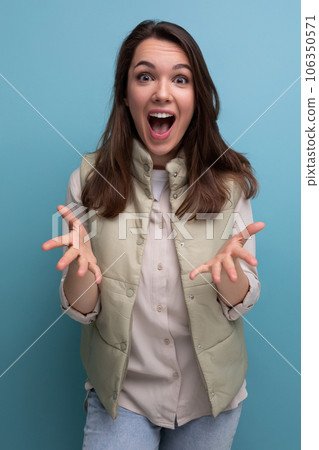 surprised brunette young woman with open mouth on studio background 106350571