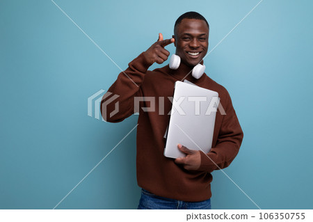 young american student studying offline with laptop and headphones on background with copy space 106350755