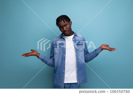 upset african man with curly hair in denim jacket 106350780
