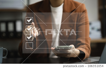 Business woman using tablet to do online checklist survey, doing assessment online survey answer test questions Digital form. Business woman using tablet to do online checklist survey, doing assessment online survey answer test questions Digital form. 106351054