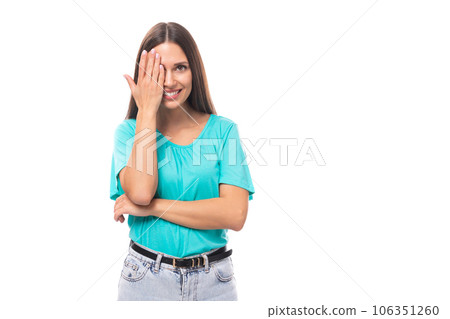 young attractive european woman with black long hair dressed in a blue t-shirt looks covering one young attractive european woman with black long hair dressed in a blue t-shirt looks covering one 106351260