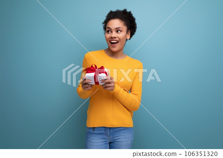 pretty joyful 20s latin woman with afro hair in casual yellow sweater got a birthday gift pretty joyful 20s latin woman with afro hair in casual yellow sweater got a birthday gift 106351320