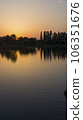 Orange sunset near the calm water of the lake 106351676