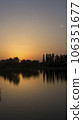 Orange sunset near the calm water of the lake 106351677