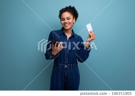 young charming brunette latin woman in blue denim suit holding credit card mockup and smartphone young charming brunette latin woman in blue denim suit holding credit card mockup and smartphone 106351905