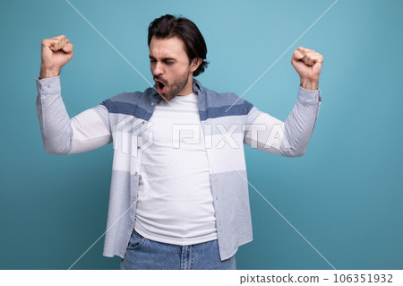 strong joyful young brunette guy on studio background strong joyful young brunette guy on studio background 106351932