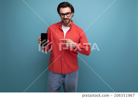 smart handsome young brunette man in glasses and red shirt with smartphone 106351967