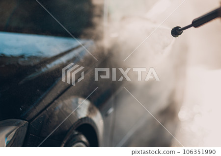 Worker washing car at self-service car wash Worker washing car at self-service car wash 106351990