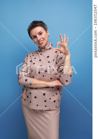 pretty caucasian young woman with short haircut dressed in a beige suit with a hollywood smile 106352047