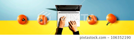 Autumn pumpkins with person using a laptop computer 106352190