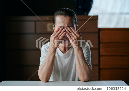 Senior woman holding her eyes with both hands Senior woman holding her eyes with both hands 106352224