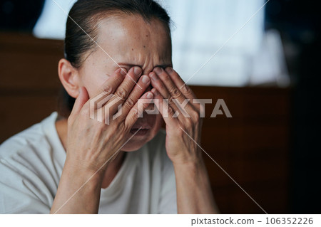 老婦人雙手捧著眼睛 老婦人雙手捧著眼睛 106352226