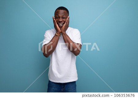 handsome young african man in white t-shirt on blue background with copy space handsome young african man in white t-shirt on blue background with copy space 106353676
