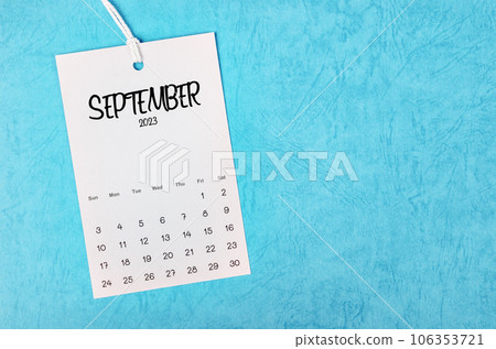 The 2023 September calendar page hanged on white rope  on blue background. 106353721