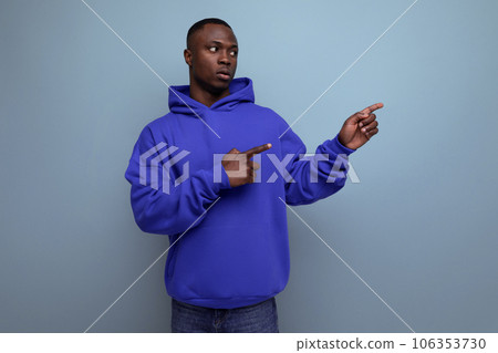 confident young black american man in casual clothes pointing to the side 106353730