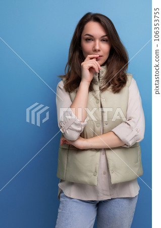 portrait of pretty brunette young woman in shirt and jeans with hair styling 106353755