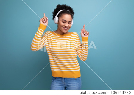 afro brunette 20s latin young woman dancing to music in headphones 106353780